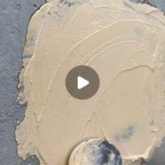 Fresh earth lime plaster being trowelled onto a wall