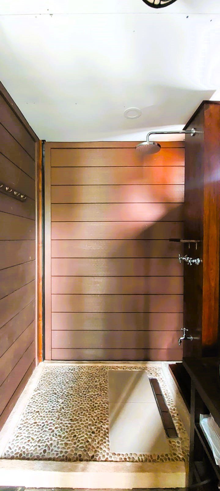A modular earthen shower base with a hand-set pebble floor, designed as a product in Bali